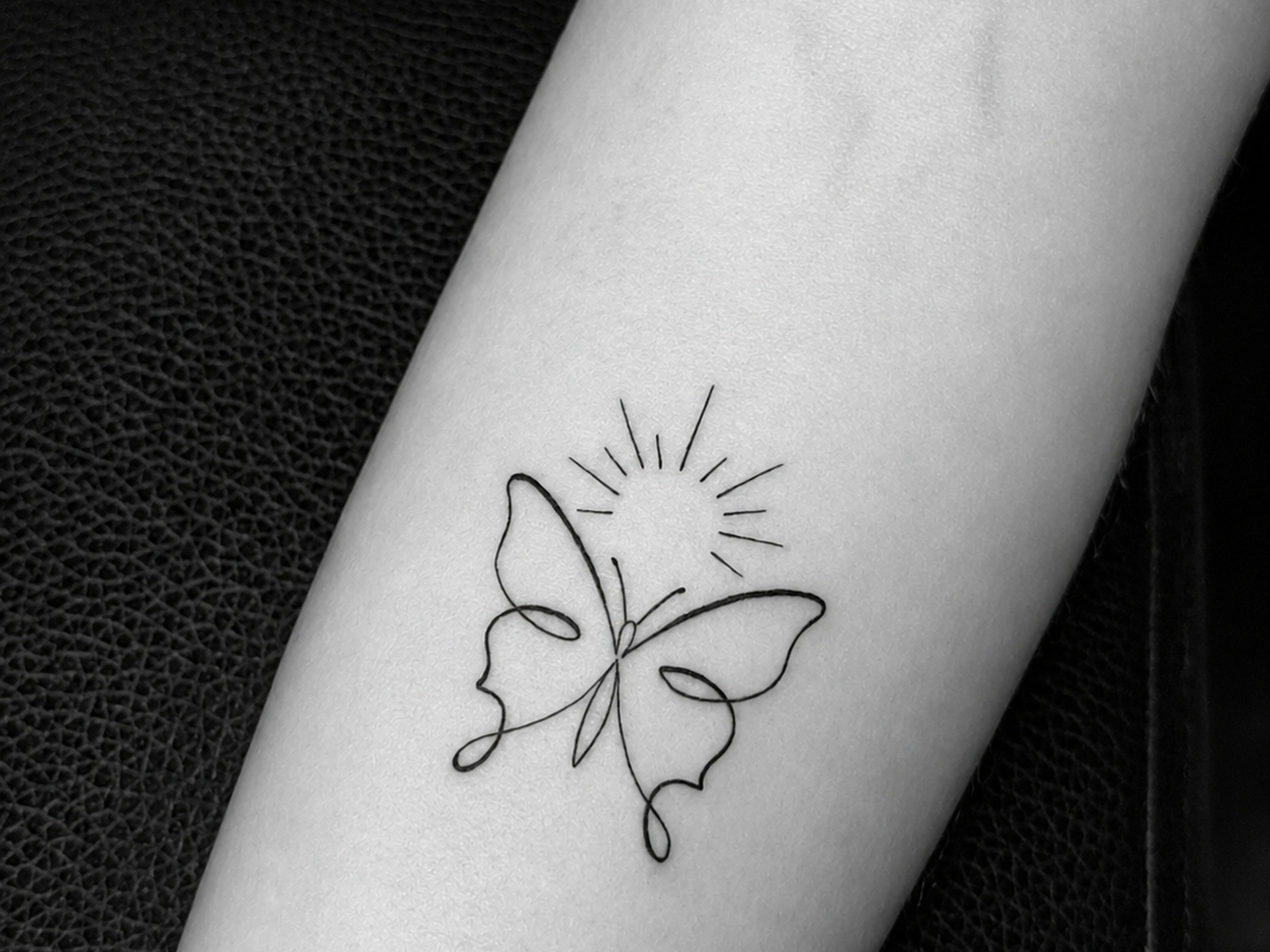 Tatuaje de mariposa y sol en línea continua