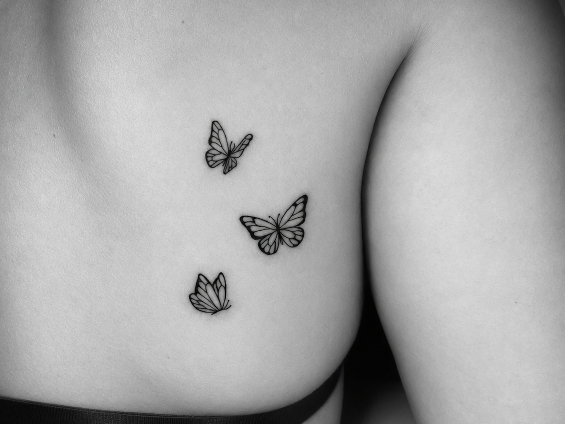 Tatuaje de tres mariposas en costado