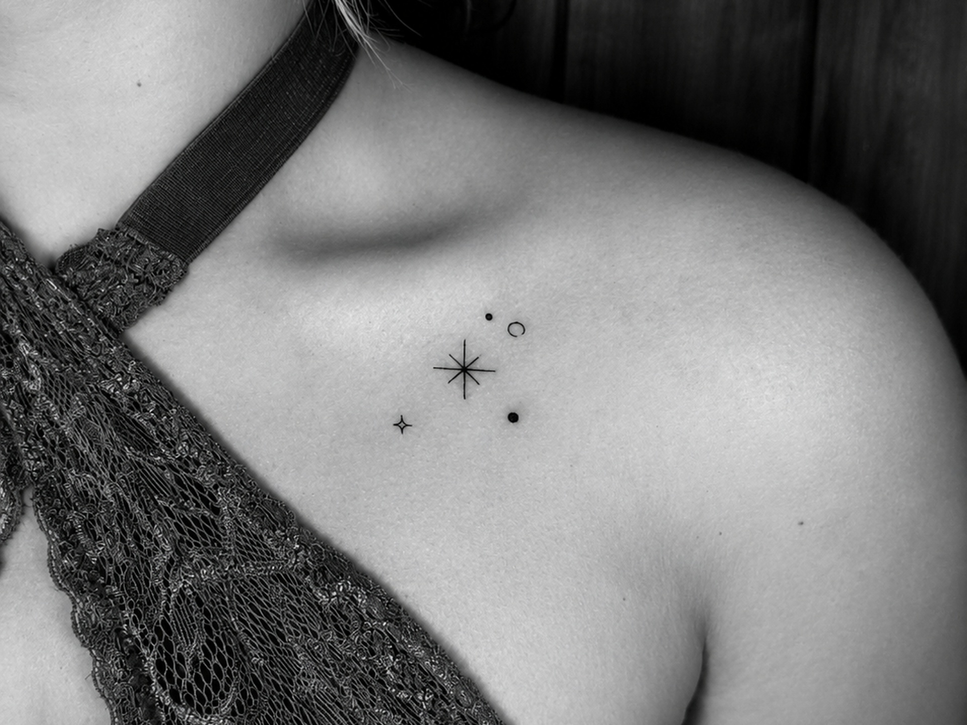 Tatuaje de estrellas y puntos en clavícula
